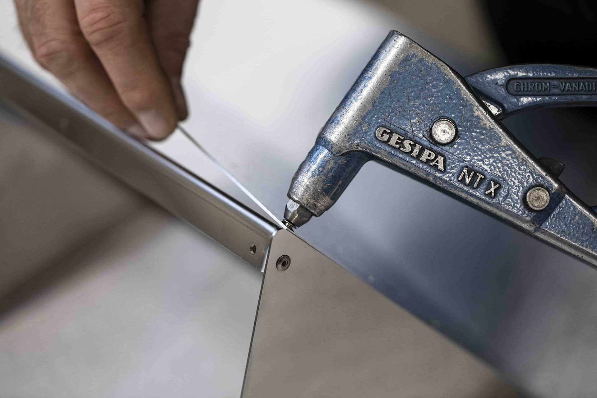 Hand
holding a piece of sheet metal and tools